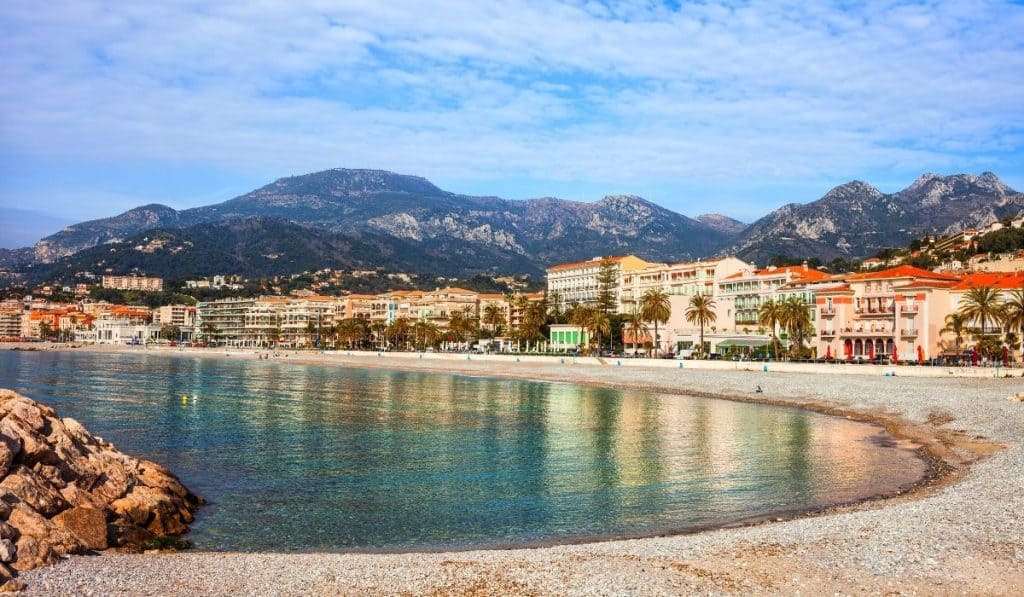 Plage du Fossan with houses reflecting on the water in Menton.